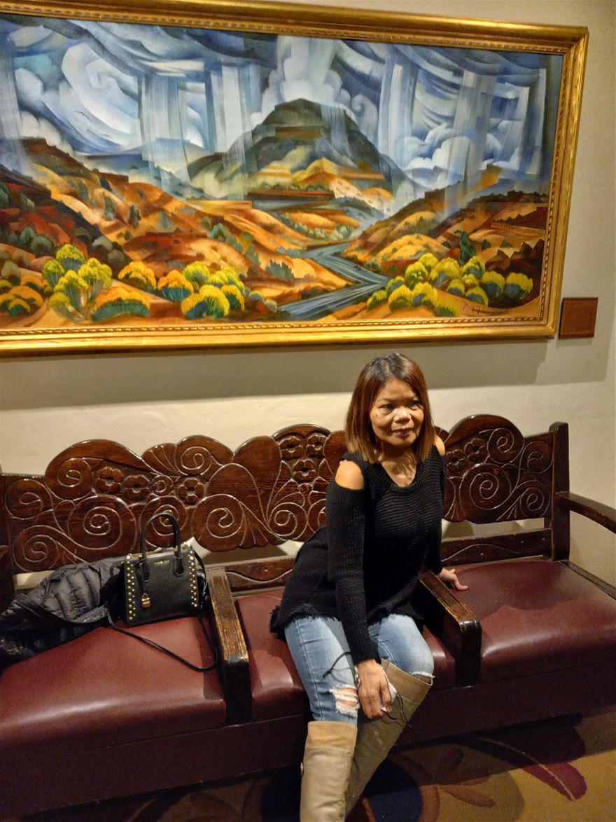 We are at La Fonda Hotel in Santa Fe New Mexico. The painting behind Farida is called Stormy Canyon. It is by Tony Abeyta. Tony Abeyta is Navajo and he is quite famous here in New Mexico.