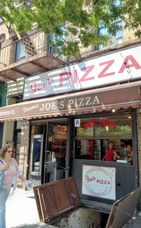 Close to Washington Square is this branch  of Joes' Pizza. There are 4 or 5 locations in NYC. I had the pizza at the Fulton Street and at the Carmine Street locations. This branch is smaller than the one on Fulton Street. Joes' Pizza is quite famous in NYC. Both of these locations have photos of well known people who have frequented Joes' Pizza. Some well known people who have eaten at Joes' Pizza are: Matthew McConaughey, Jimmy Fallon, Anne Hathaway, Bill Murrey, Kevin Bacon, Leonardo Di Caprio, Danny Devito, and Conan O'Brian. The location photographed here was used in the Spiderman movies as the place where Peter Parker worked when he was delivering pizzas. During the filming of Spiderman movies, this branch was located at 233 Bleecker Street and recently moved here to 7 Carmine Street. This 7 Carmine Street location is 3 buildings away from its original Bleecker Street location which was used in Spiderman 2. Oh, and the pizza is very good.